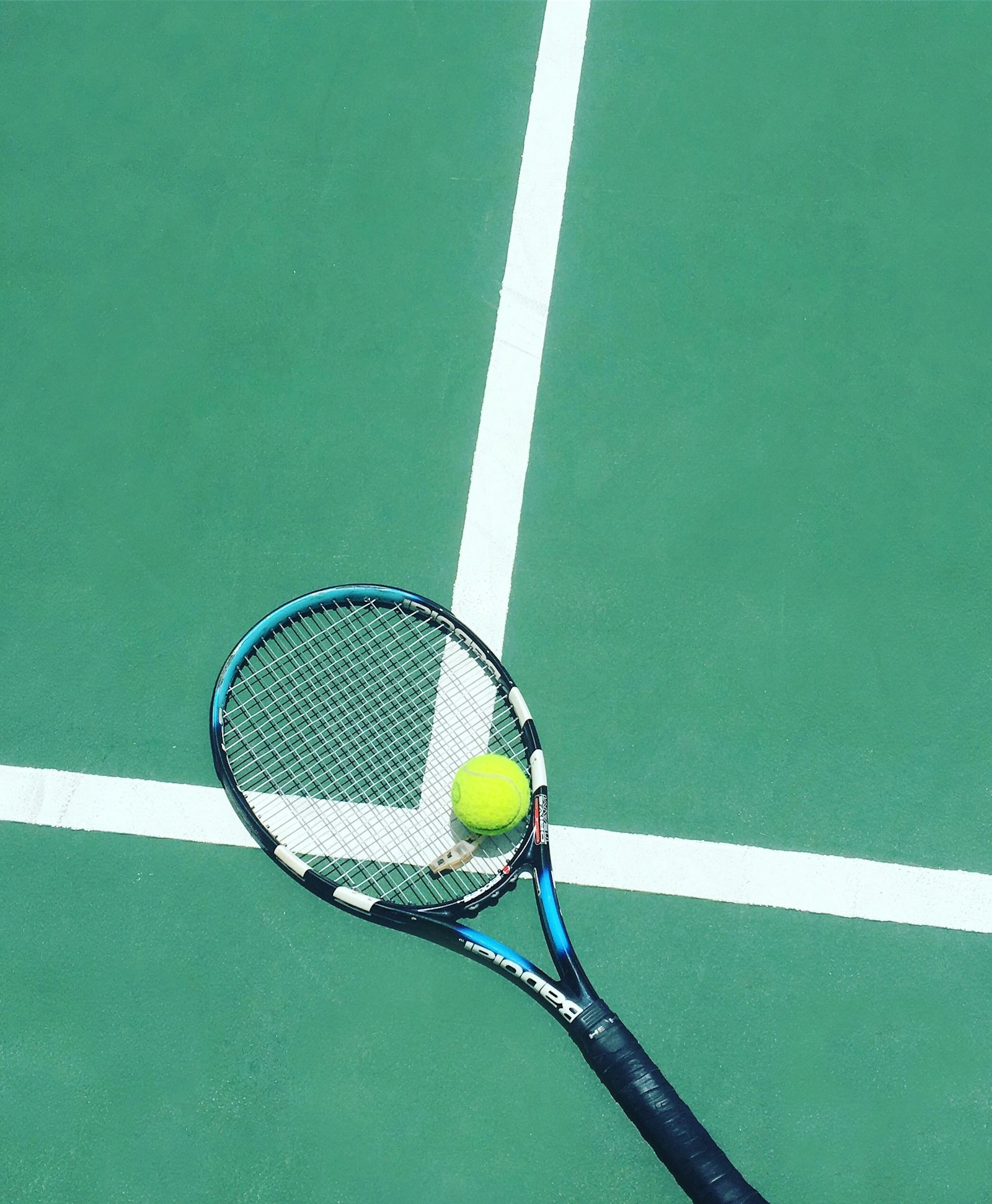 Racquet and ball resting on a court line