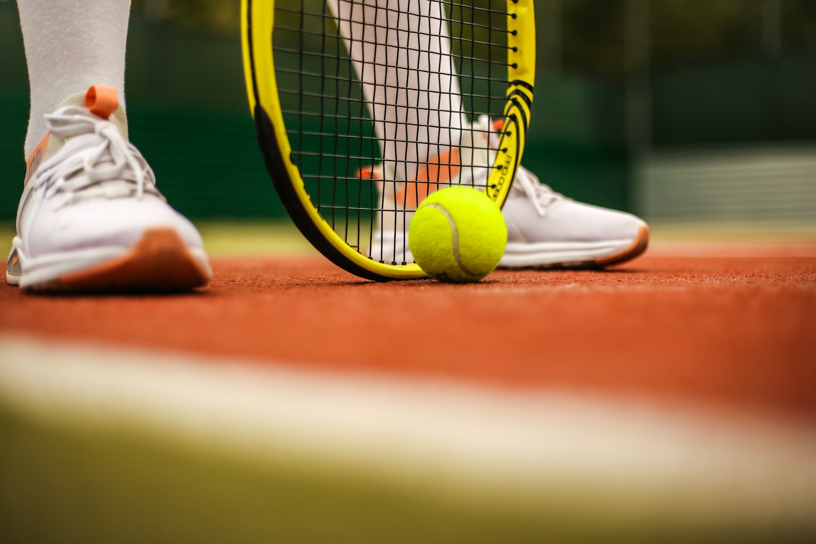Player picking up a tennis ball with their racquet